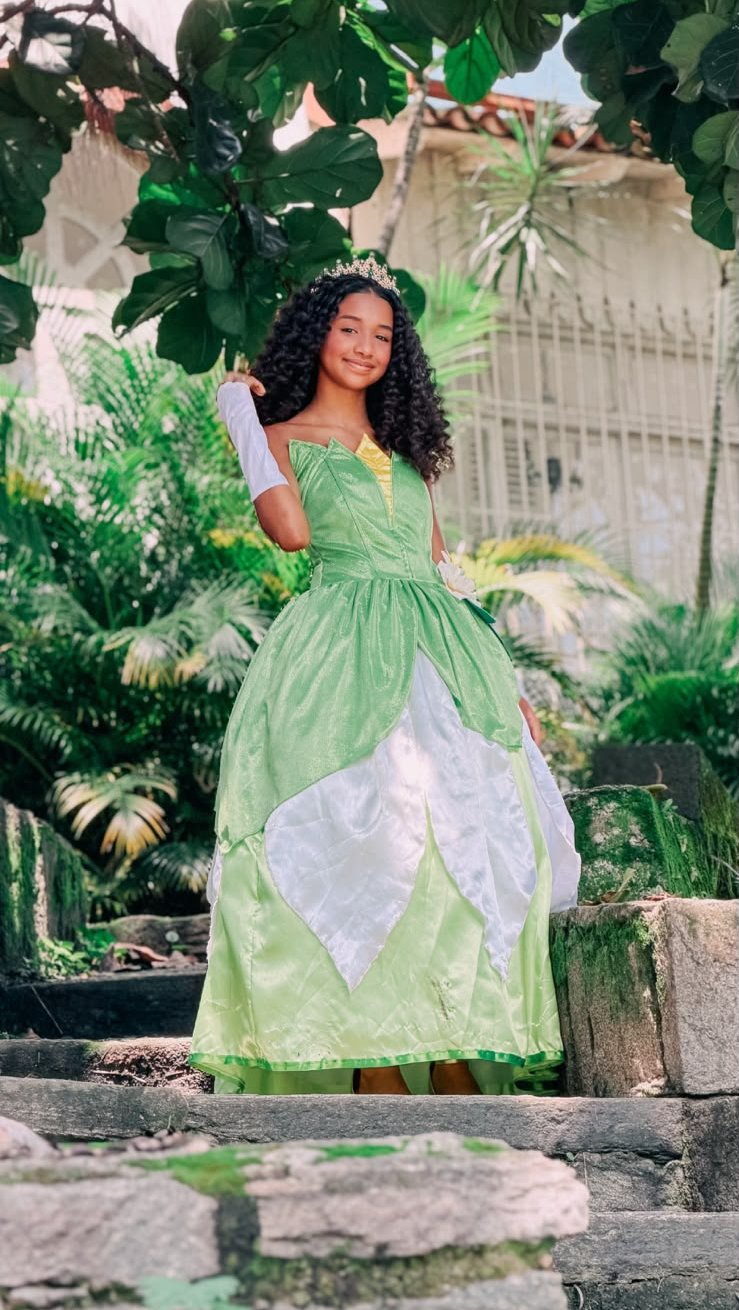 Camille de pé na escadaria entre as plantas